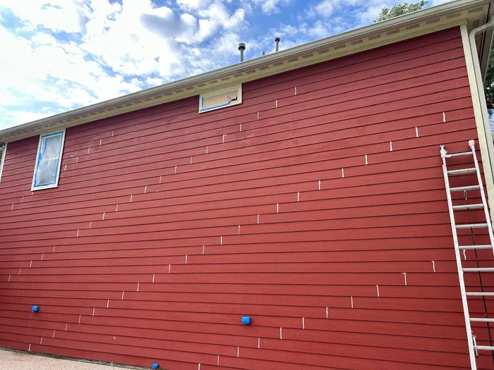 Red house exterior repaint in progress in Houston