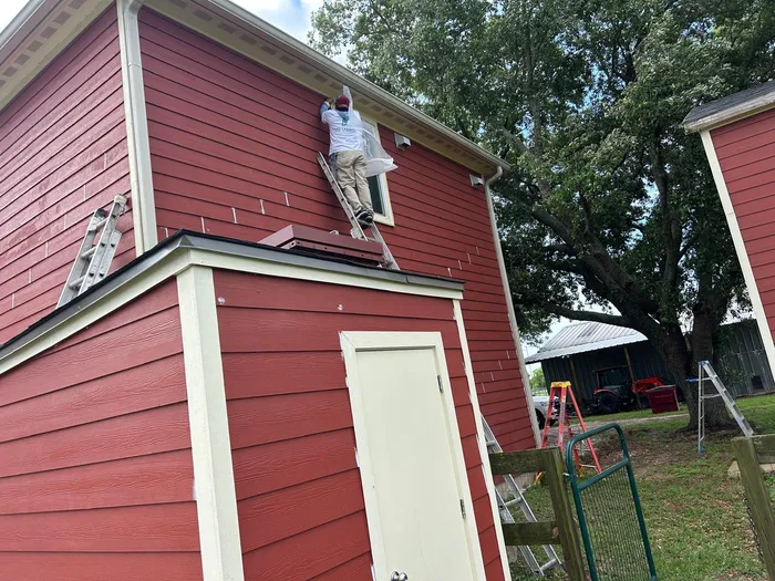 Full exterior repaint of a red house in Houston