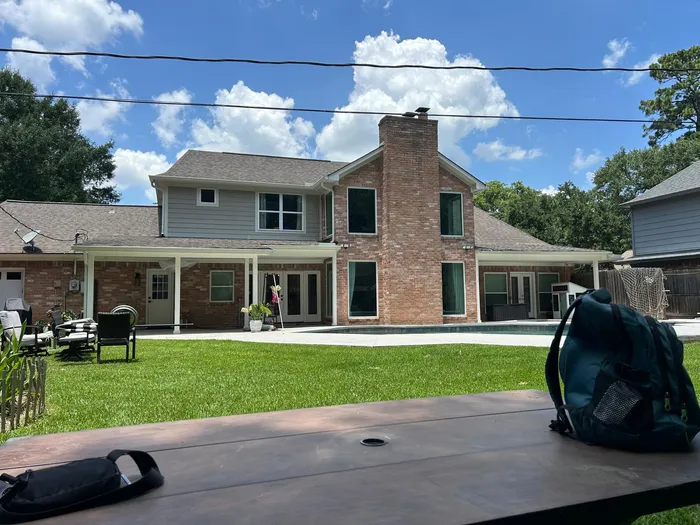 Dark exterior house repaint on a wooded Houston-area lot
