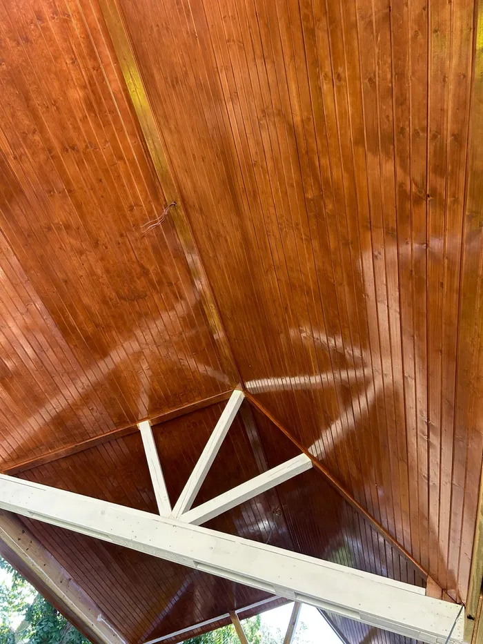 Stained wood covered patio ceiling detail with corner beam
