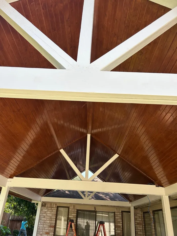 Finished covered patio ceiling with painted white trusses