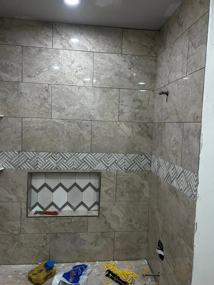 Bathroom shower tile installation with mosaic niche detail