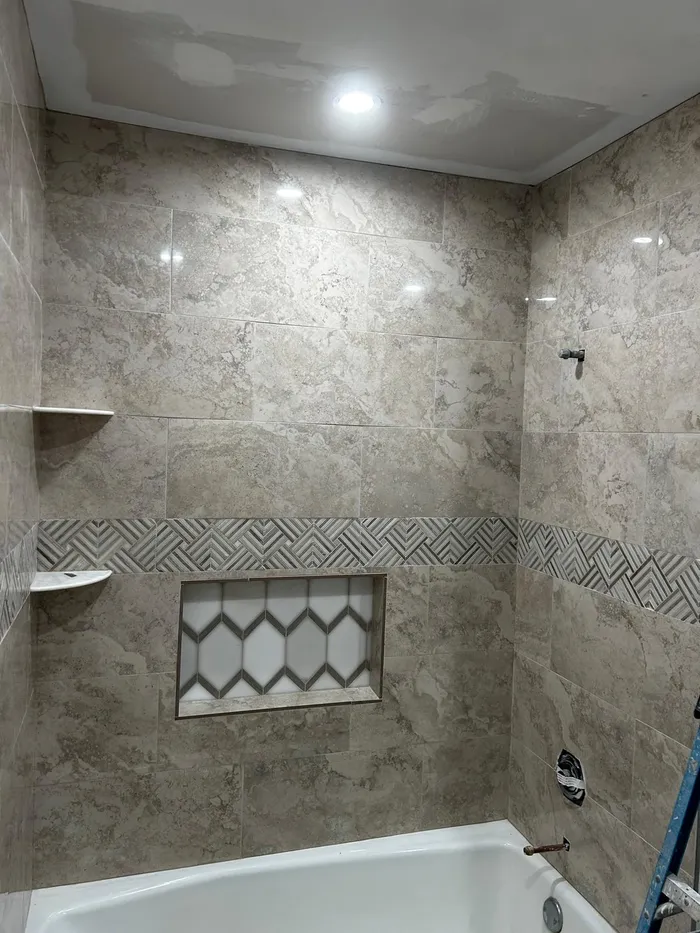 Finished tile shower surround with mosaic accent band